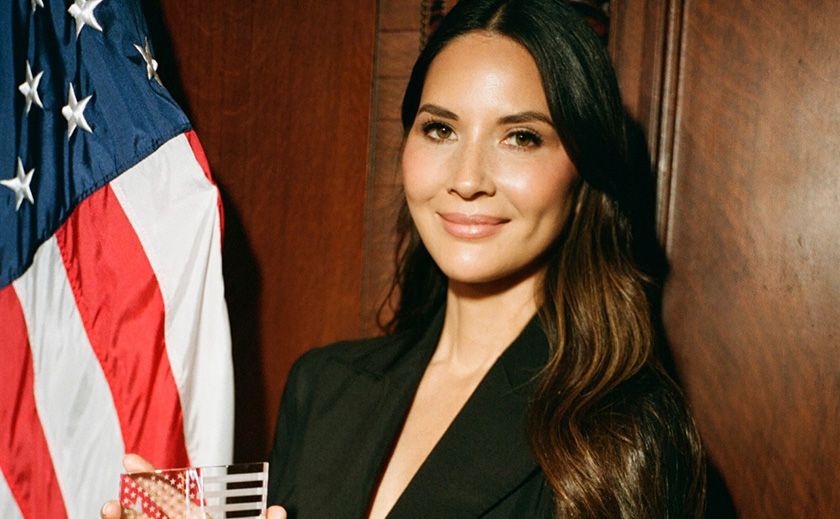 Actress Olivia Munn stands with her award at the 2025 Congressional Families Luncheon Award ceremony.