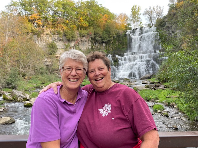 Barb, right, and her wife Sarah, left, smiling in front of a gorge.