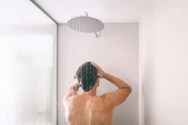 A man in the shower washing his hair