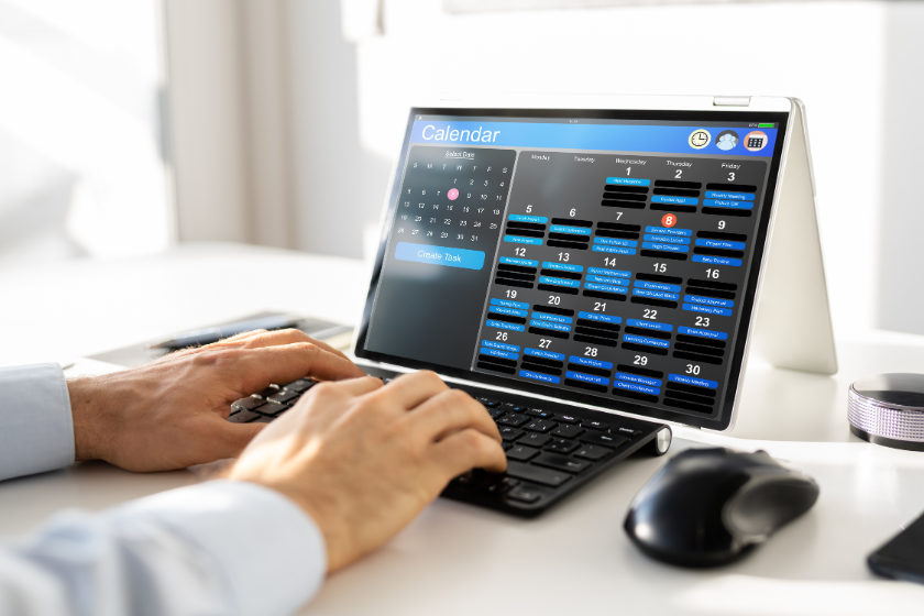 A man on a computer looking at his calendar